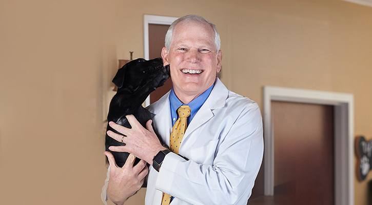 Pet Boarding and Dog Daycare in West Rome, GA Dr. Pate, a veterinarian at West Rome Animal Clinic, with a dog in dog daycare and boarding services
